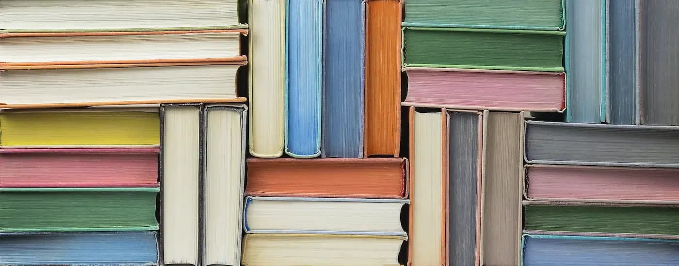 Stack of colorful books with varied spines arranged closely together
