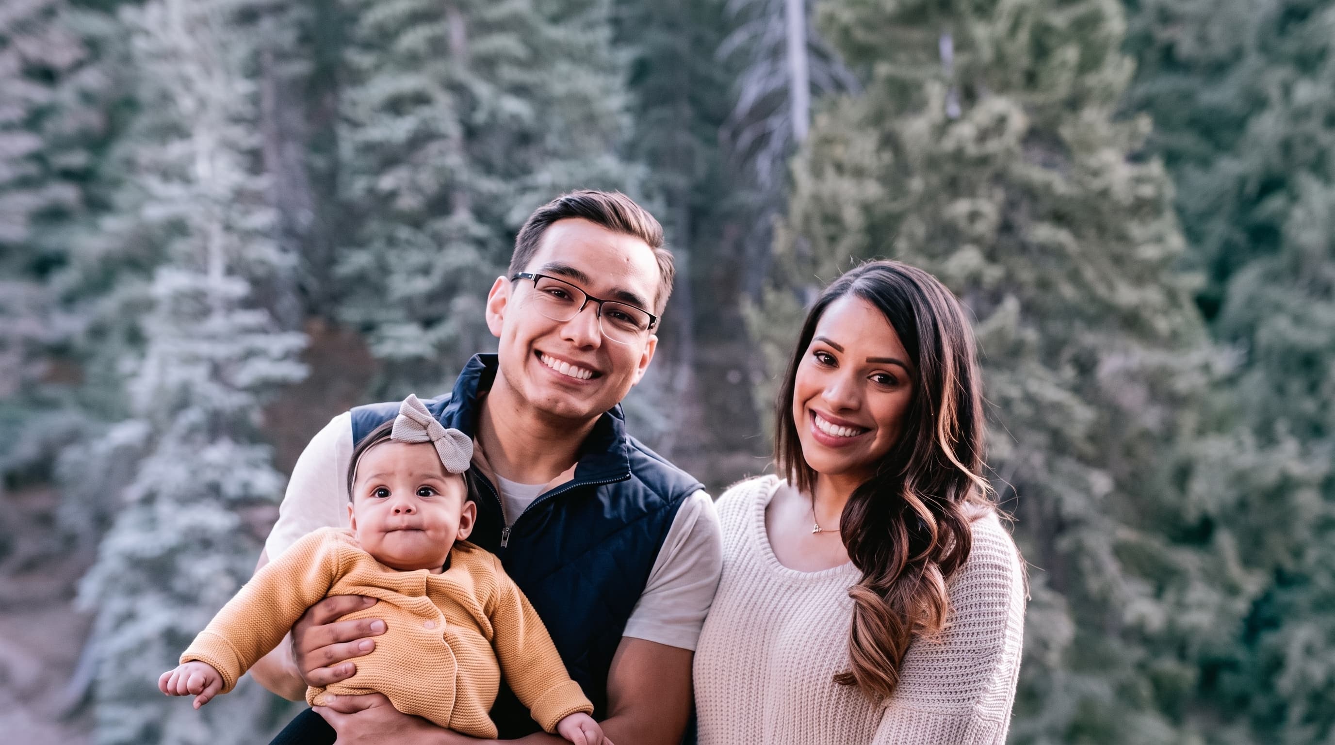 Astrid Cabas with her husband and daughter outdoors in a forest setting