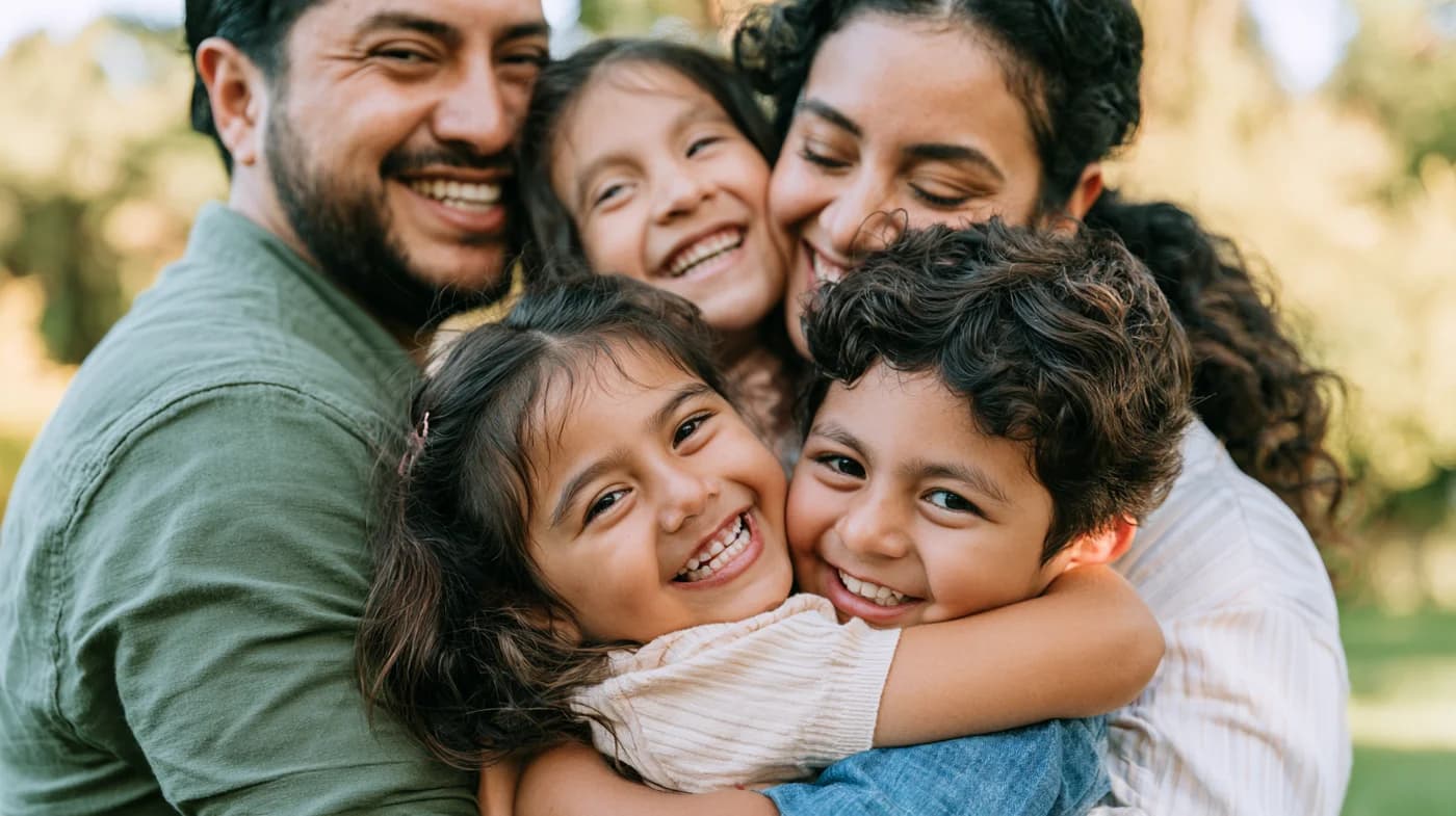 Smiling family of four enjoying time together on a residential patio at sunset