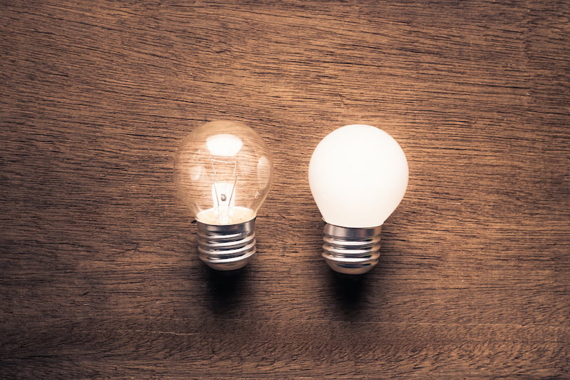 Different small light bulbs glowing on wood background